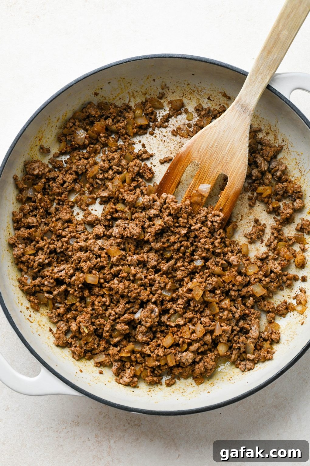 How to make Dairy Free Queso Fundido with Ground Beef: Cooked ground beef and onion in skillet with spices mixed in.