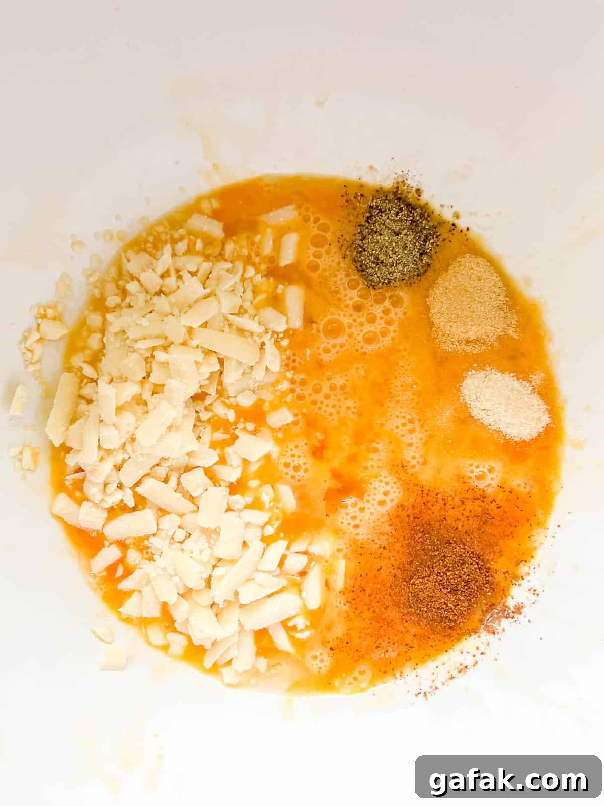 Spices added to eggs in a bowl.