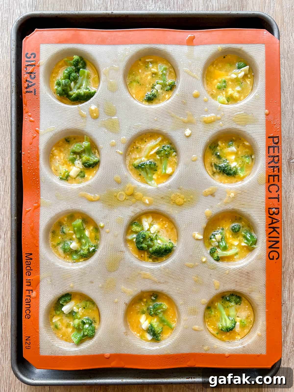 Broccoli egg muffin batter in egg tins.