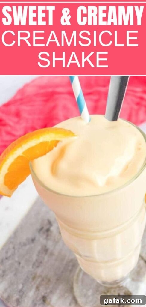 Creamsicle Shake in a glass with straw and spoon inside glass