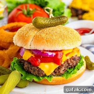 Square close up image of Cheeseburger Recipe on marble platter with onion rings and pickles