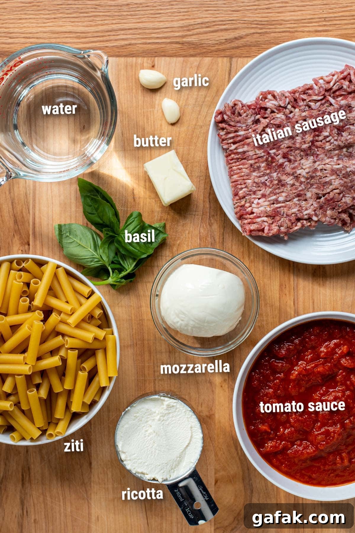 uncooked baked ziti ingredients laid out on a cutting board.