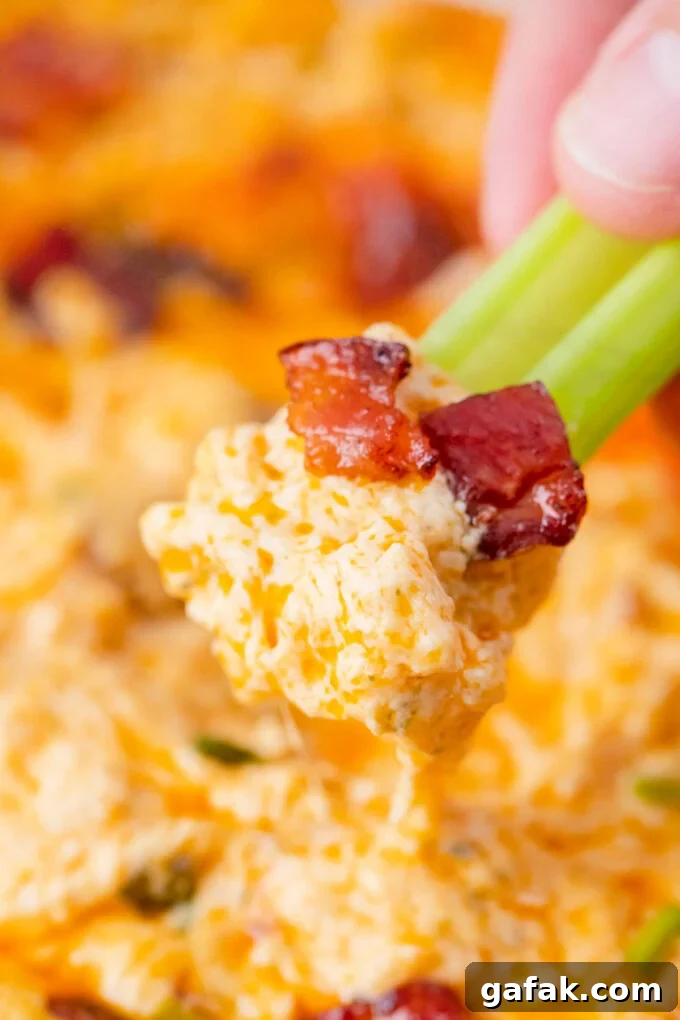 Buffalo crack chicken dip on a celery stick.