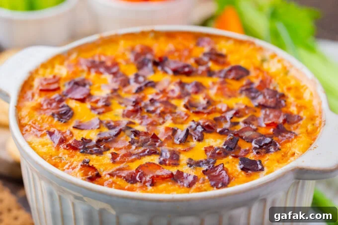 Baked Buffalo crack chicken dip topped with crispy bacon.