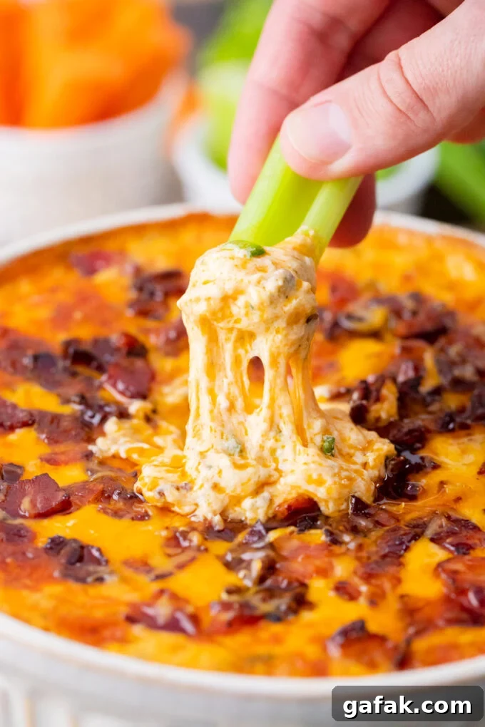 Dipping a celery stick into Buffalo crack chicken dip.