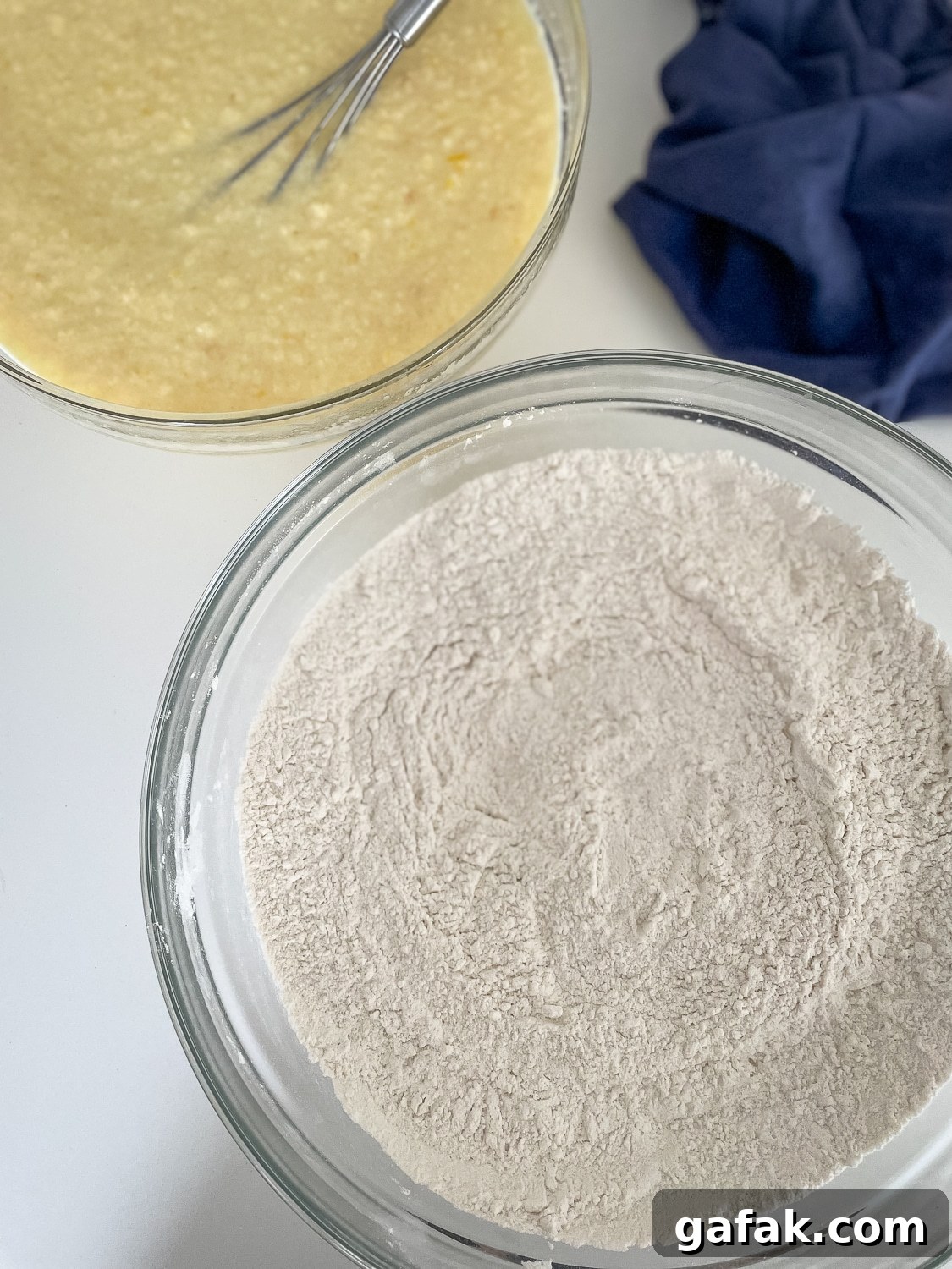 mixed dry ingredients in a glass bowl with the mixed wet ingredients in the background