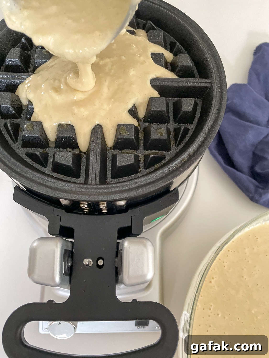 batter being poured into a waffle iron
