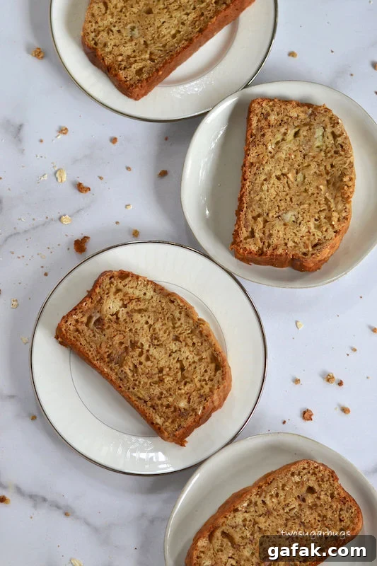 Four plates with slices of peanut butter oat banana bread
