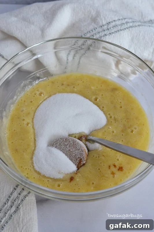 Mashed bananas, eggs and sugar in a glass bowl