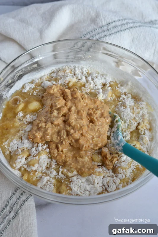 Peanut butter and oats being mixed into banana bread batter