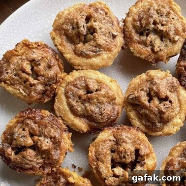 Pecan pie tarts on a white plate.