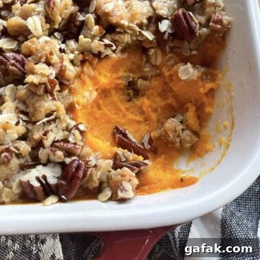 A pan of sweet potato casserole with a scoop missing.