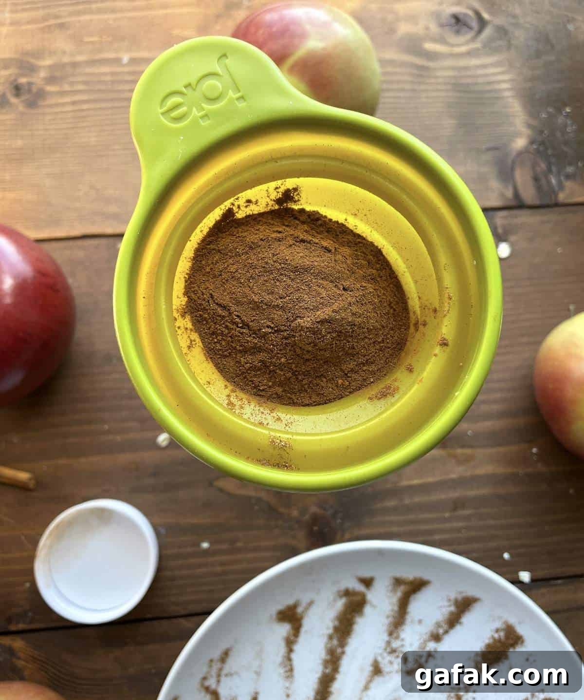 Apple pie spice mix being funneled into a jar.