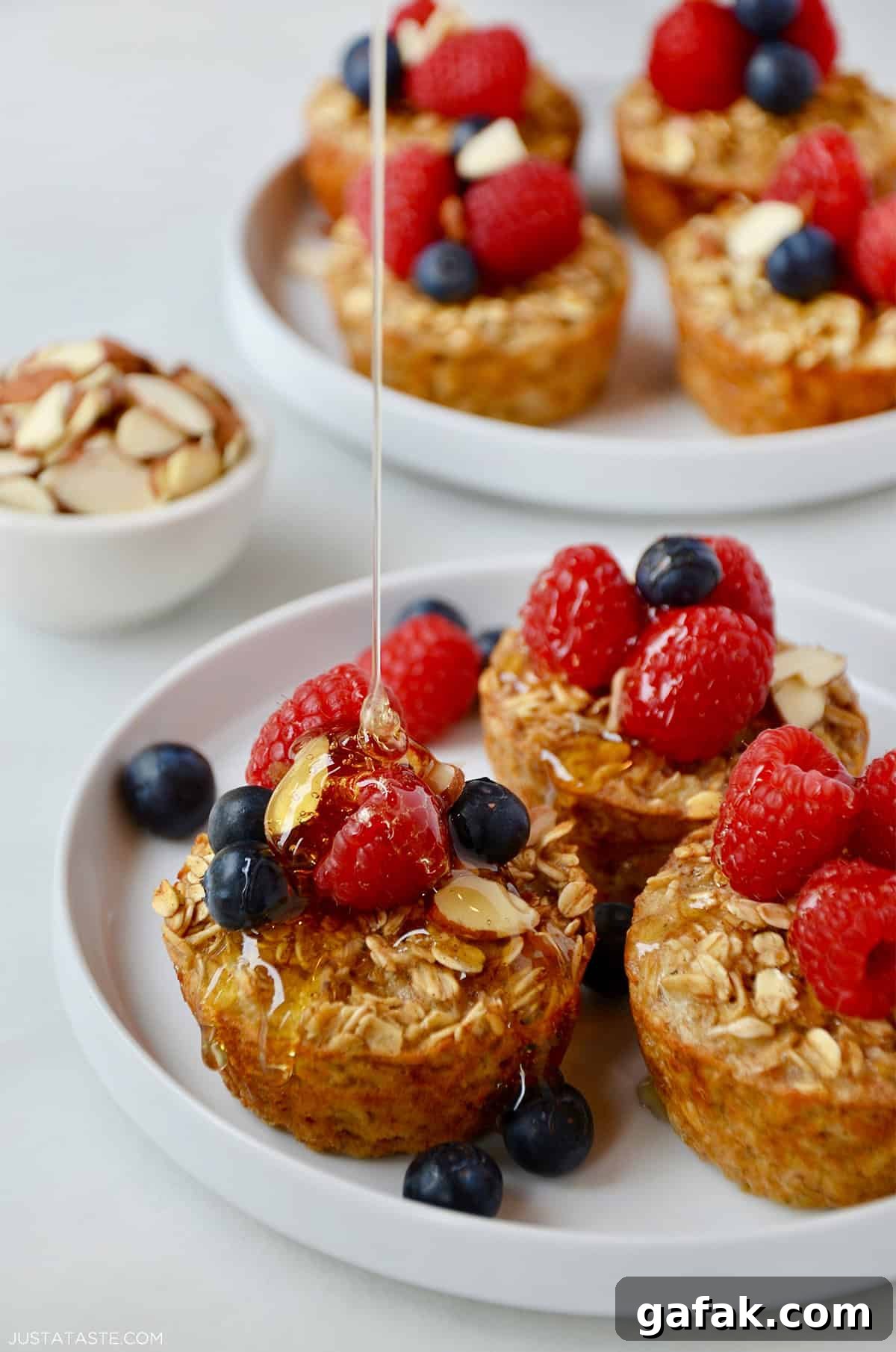 Baked Oatmeal Cups topped with fresh raspberries and blueberries.