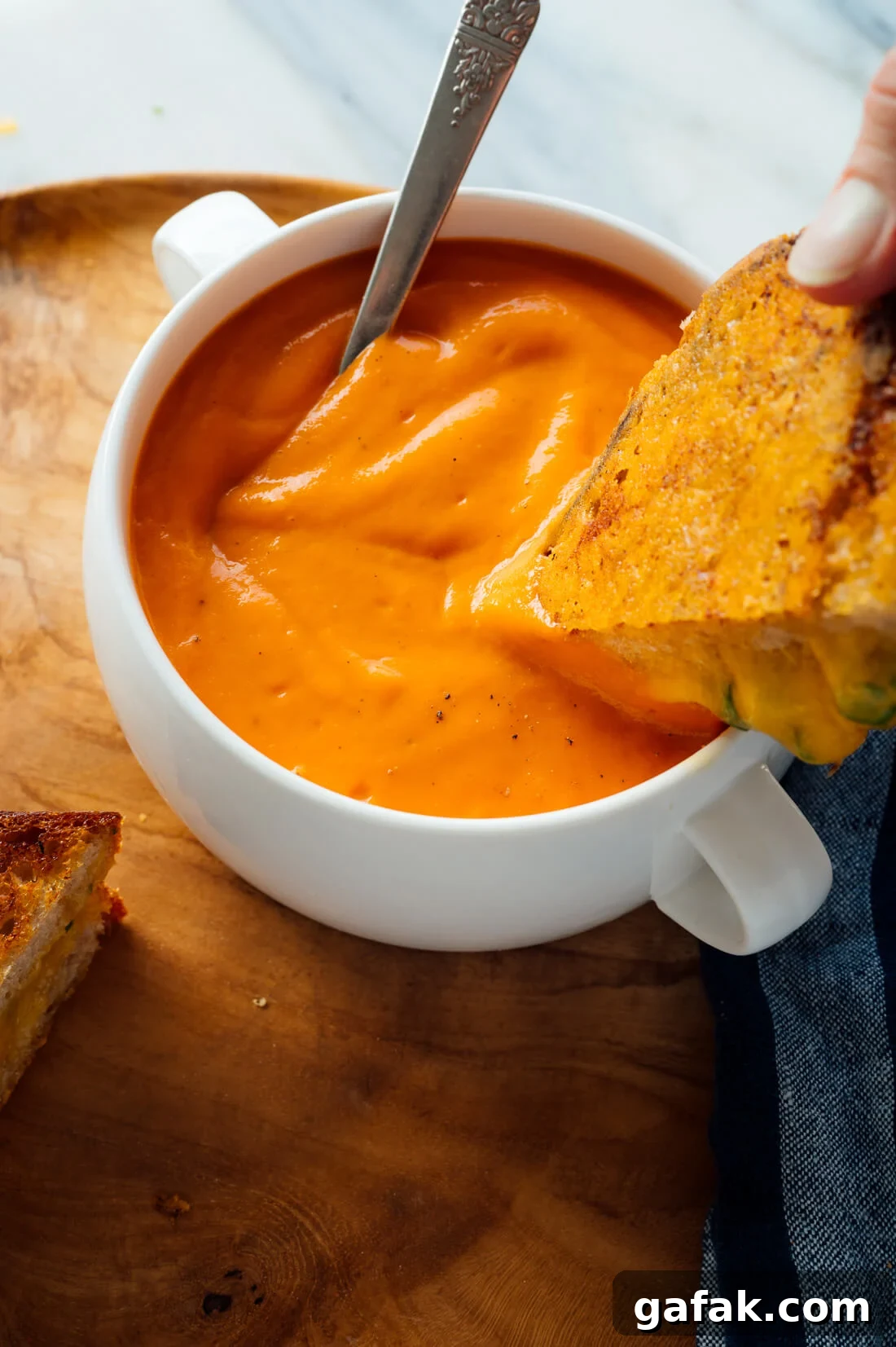 grilled cheese dipping into tomato soup
