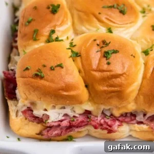 Classic Reuben Sliders with Melted Swiss and Tangy Thousand Island 12 Slow cooker reuben sliders in white pan.