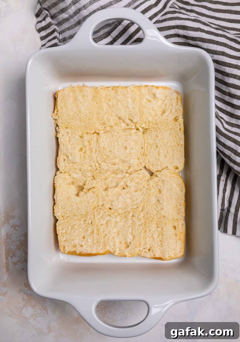 Classic Reuben Sliders with Melted Swiss and Tangy Thousand Island 5 Hawaiian rolls halved in the bottom of a white baking dish.