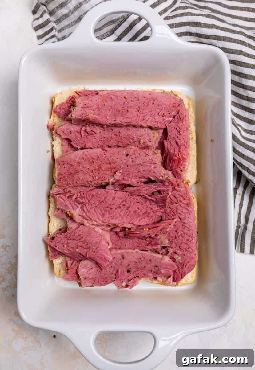 Classic Reuben Sliders with Melted Swiss and Tangy Thousand Island 6 Corned beef sliced and layered on top of rolls.