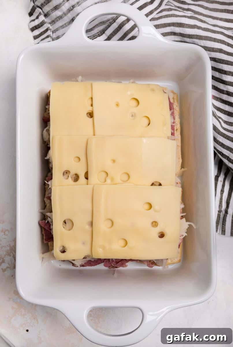 Classic Reuben Sliders with Melted Swiss and Tangy Thousand Island 8 Swiss cheese on top of sauerkraut and corned beef.