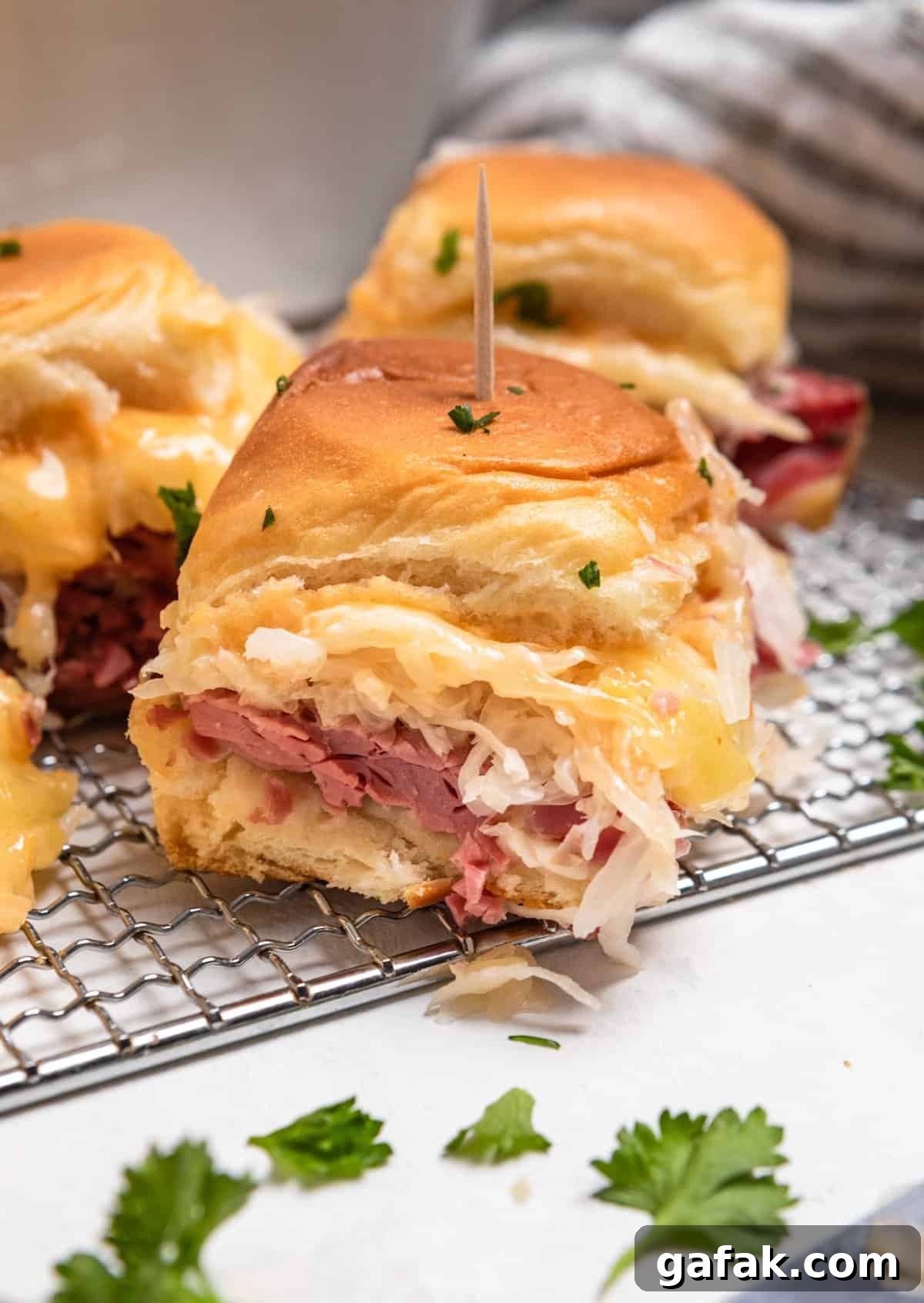 Classic Reuben Sliders with Melted Swiss and Tangy Thousand Island 10 Reuben slider held up to show close up of sandwich.