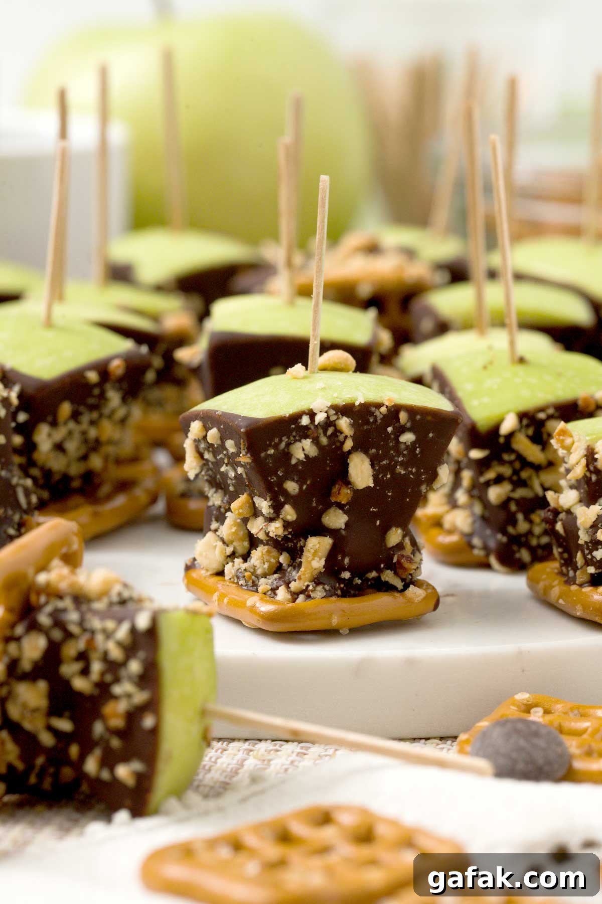 A close-up of a caramel apple pretzel bite with medjool dates and peanuts.