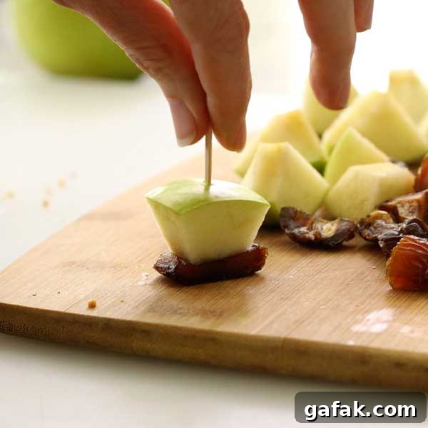Pushing a toothpick through the apple chunk and date piece.