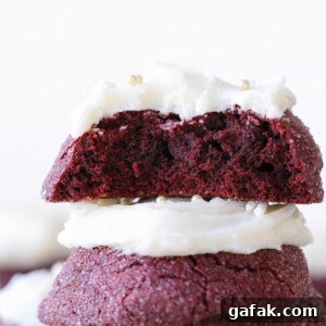 The inside of a red velvet cookie stacked on top of another red velvet cookie.