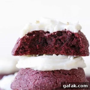 The inside of a red velvet cookie stacked on top of another red velvet cookie.