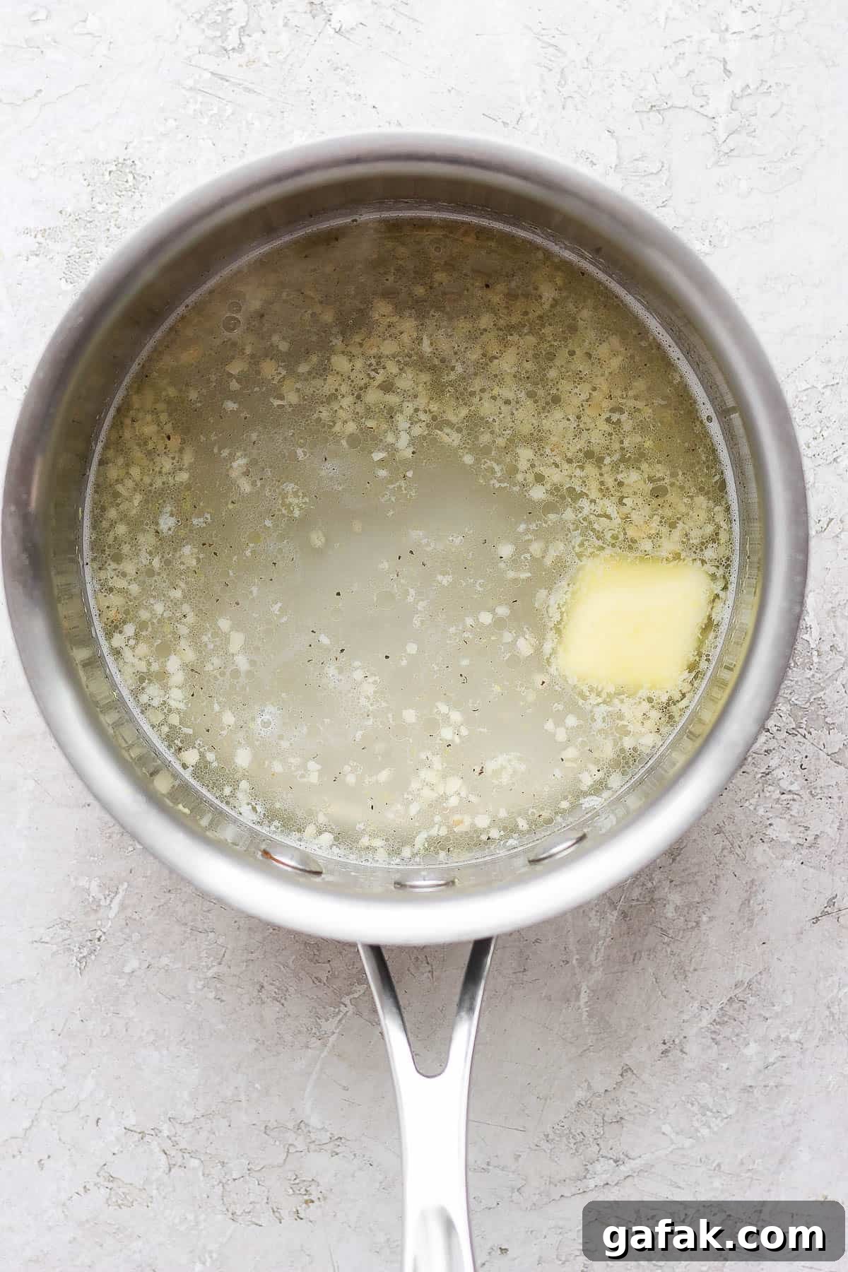 Water, butter, salt, pepper, and lemon zest added to the sauce pan.