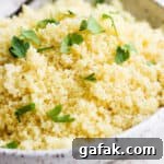 Side shot of a bowl of lemon couscous with fresh parsley on top.