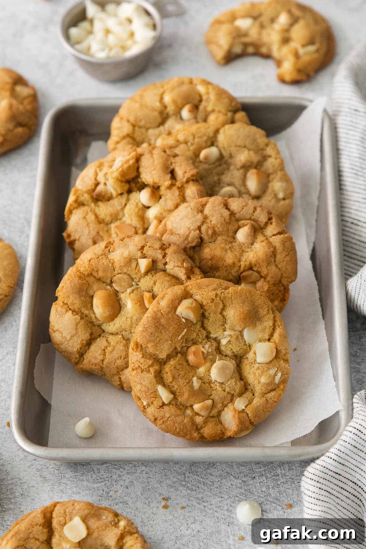 White chocolate macadamia nut cookies on a baking tray with parchment paper