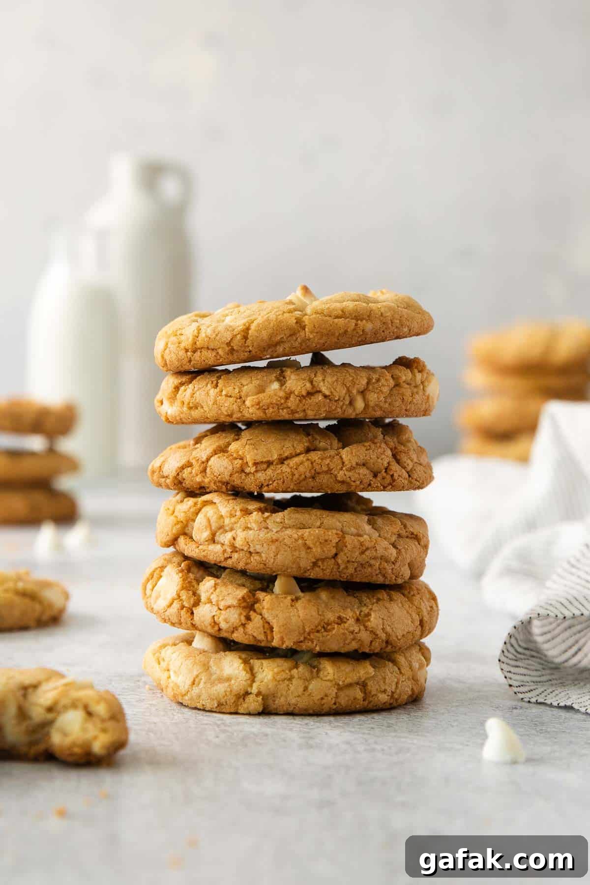 White chocolate macadamia nut cookies stacked on a countertop