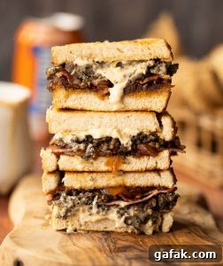3 haggis sandwiches stacked on each other on wooden board