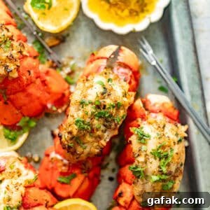 juicy baked lobster tails on a serving dish topped with a generous amount of garlic butter and fresh parsley.