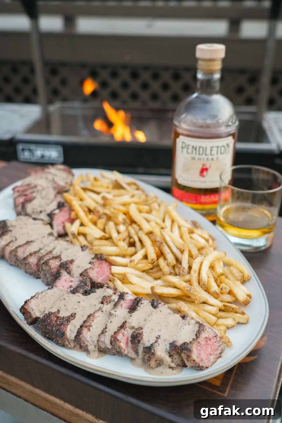 The full Steak au Poivre meal complete with the bottle of whisky and glass. 