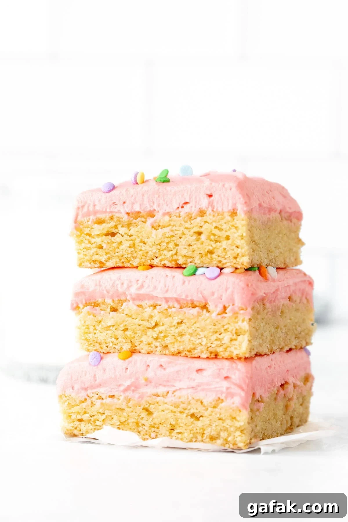 Stack of three sugar cookie bars decorated with pink frosting