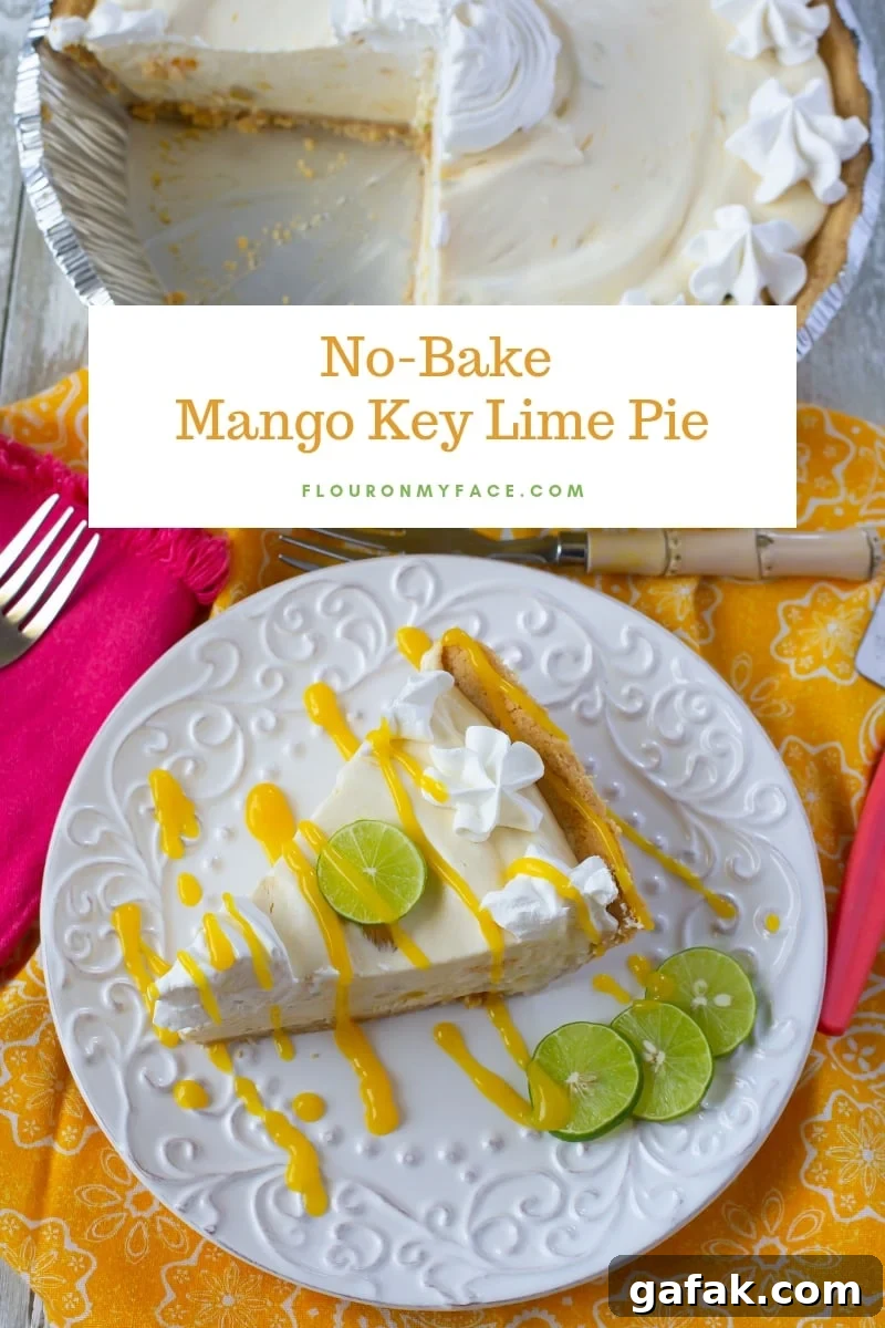 A slice of No-Bake Mango Key Lime Pie with a drizzle of mango sauce, whipped cream and a slice of fresh key lime for a garnish on a white dessert plate . The cut  pie  is in the background.