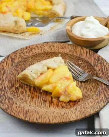 A slice of Rustic Peach Pie on a brown plate with the cut pie in the background.