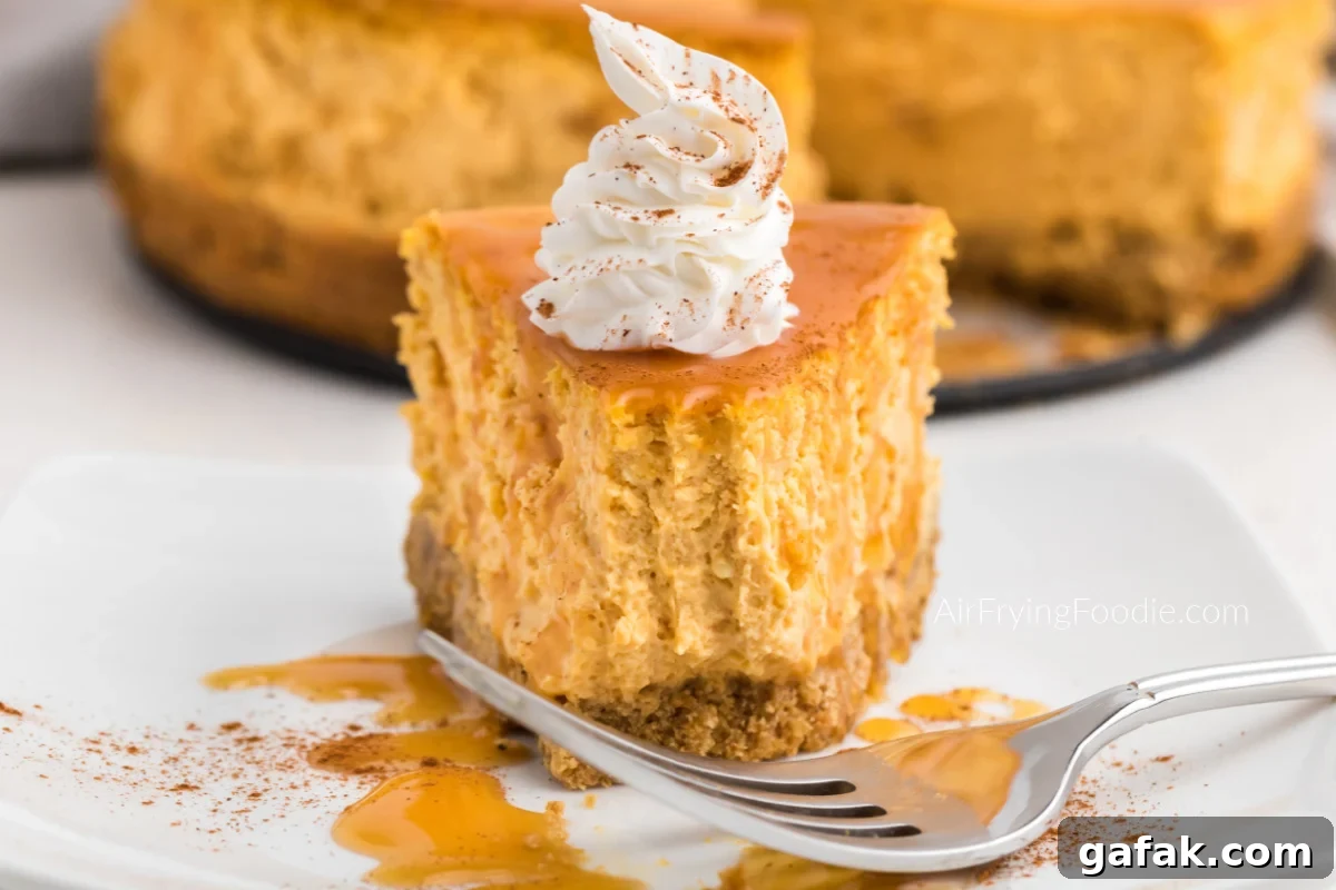 Bite shot of air fryer pumpkin cheesecake with caramel, icing, and a dusting of cinnamon.