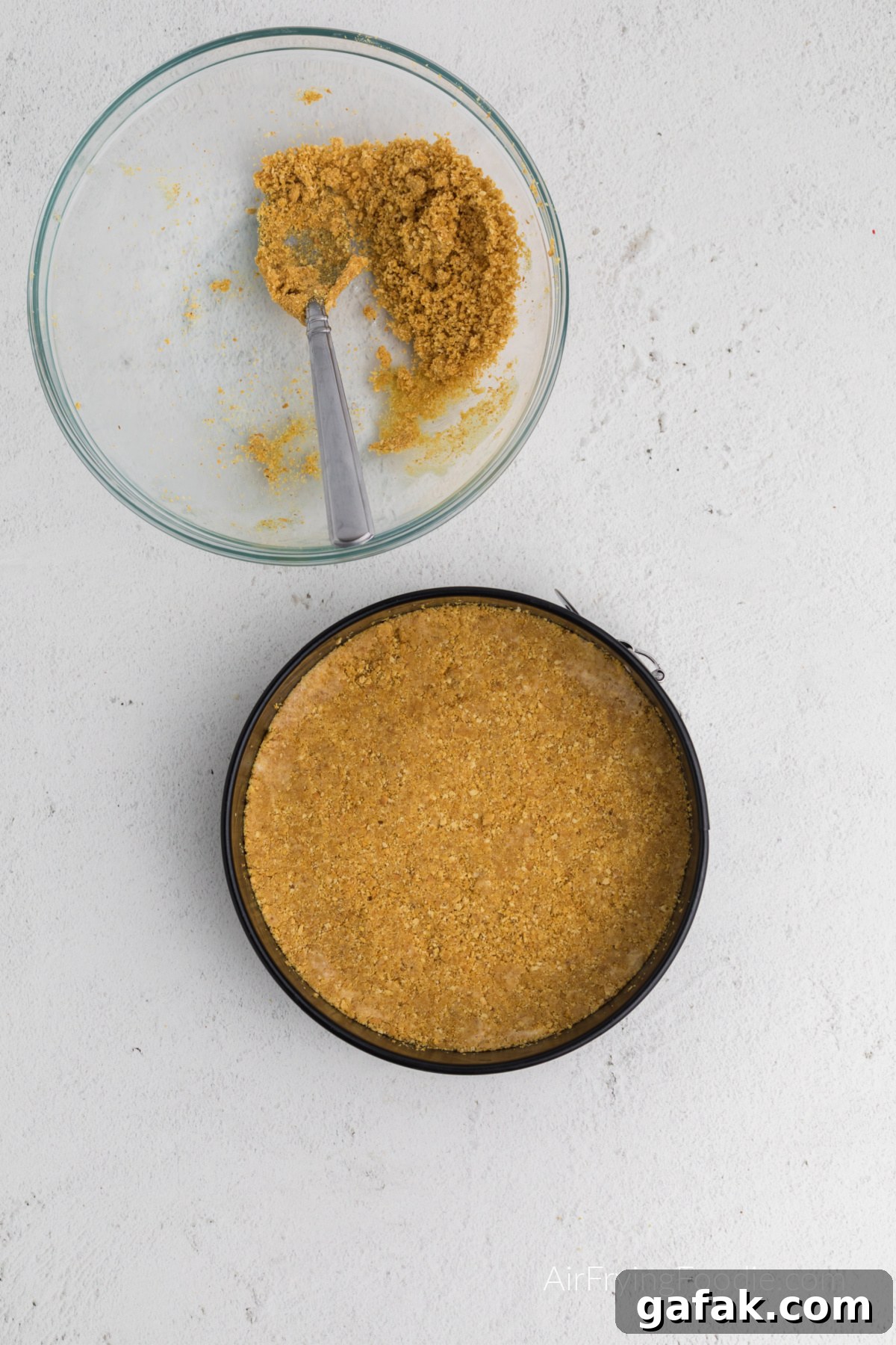 Graham cracker crumbs and butter pressed into the bottom of the springform pan.
