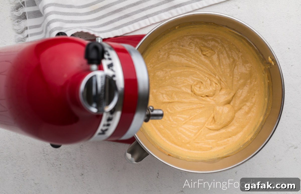 pumpkin cheesecake mixture in the bowl of the stand mixer.