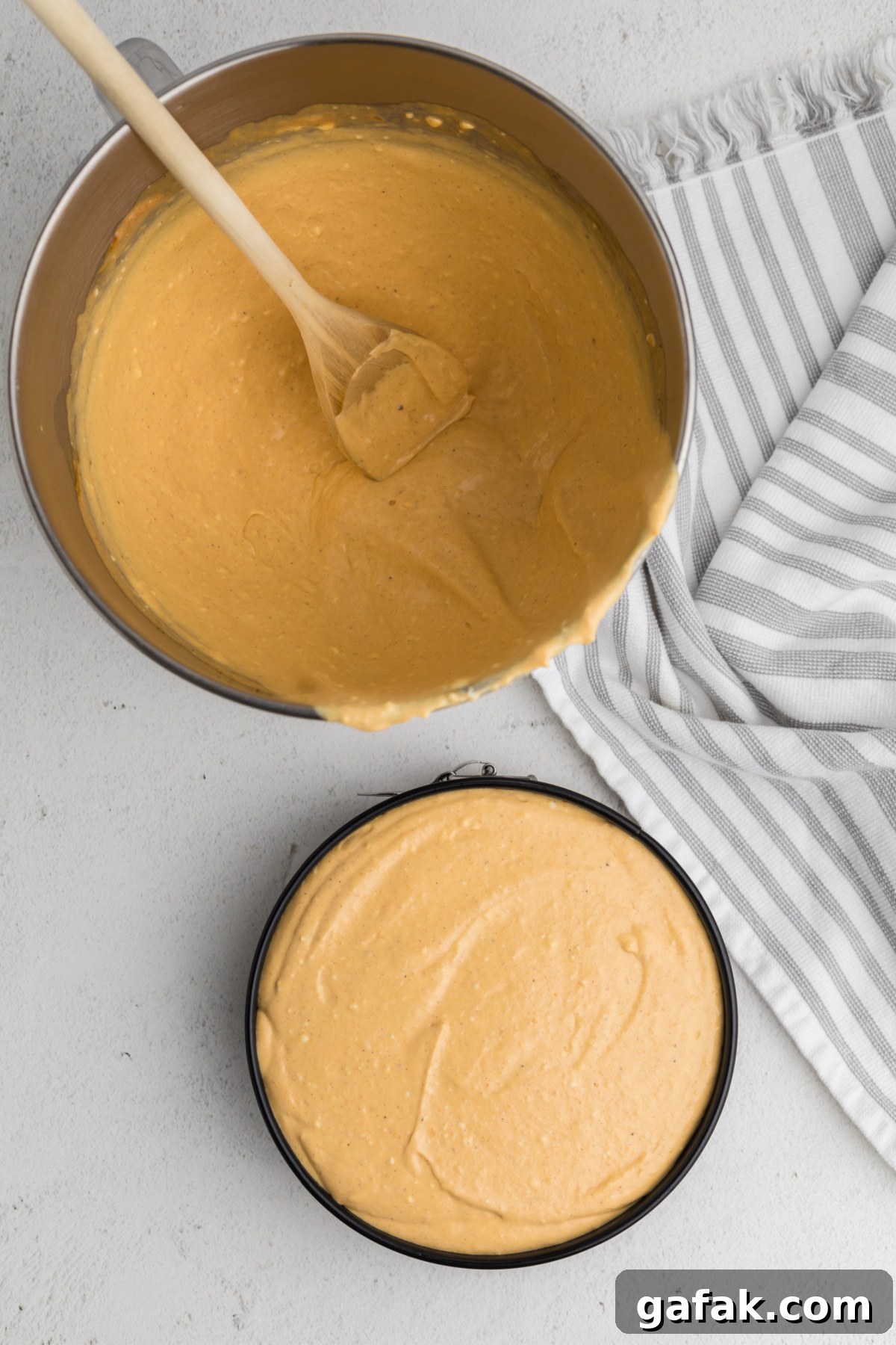 Pumpkin cheesecake poured over the graham cracker crust, and ready to be cooked. 