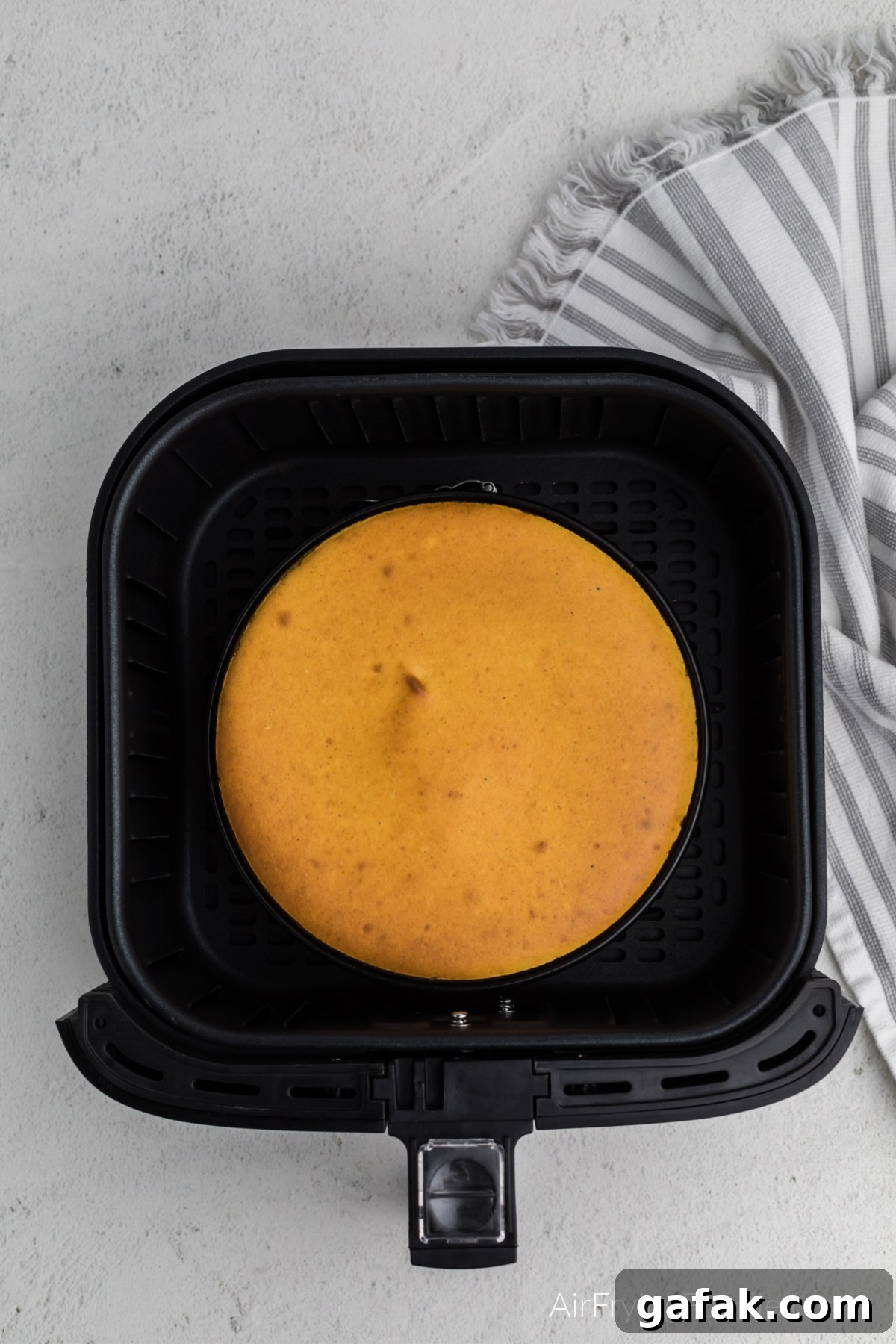 Fully cooked pumpkin cheesecake in the air fryer basket