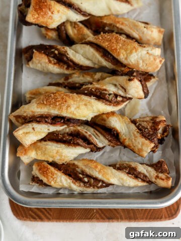 Puff pastry twists with Nutella inside on a small baking tray.