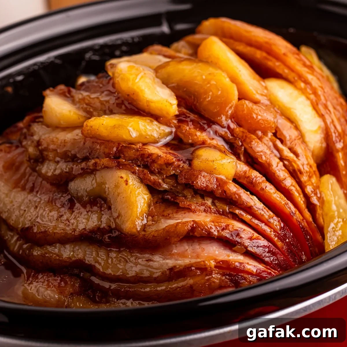 Slow Cooker Apple Glazed Ham in a red crockpot sitting on table 