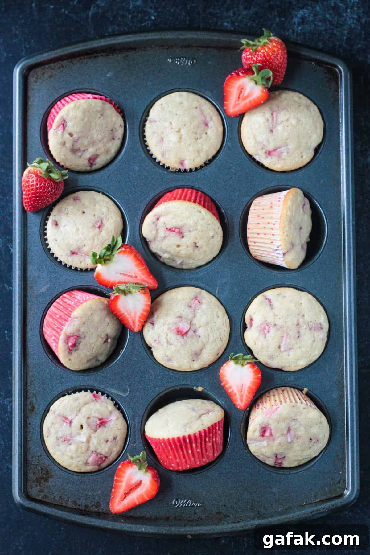 Twelve baked vegan strawberry cupcakes in a cupcake pan.