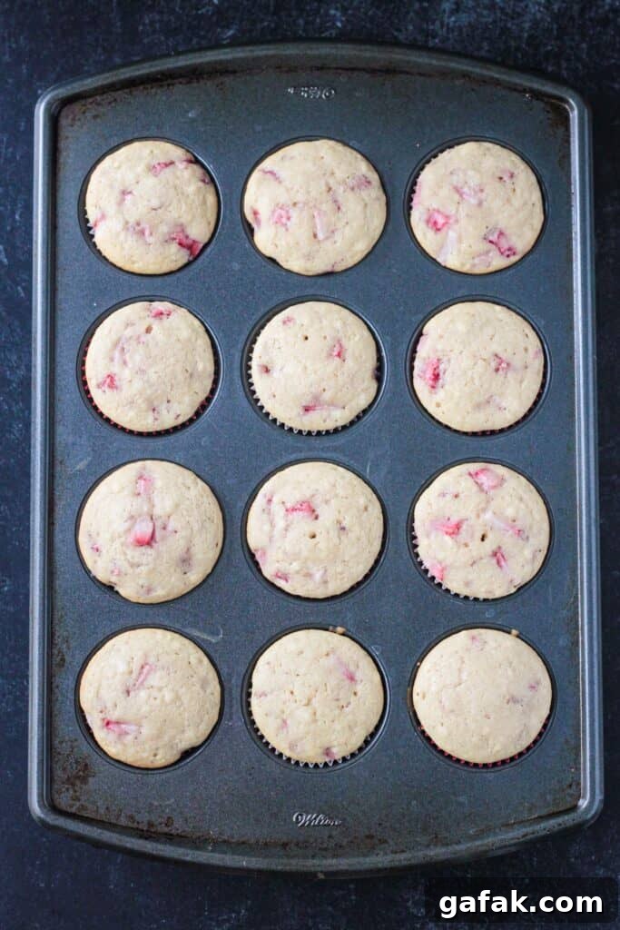 Baked strawberry cupcakes in a cupcake pan.