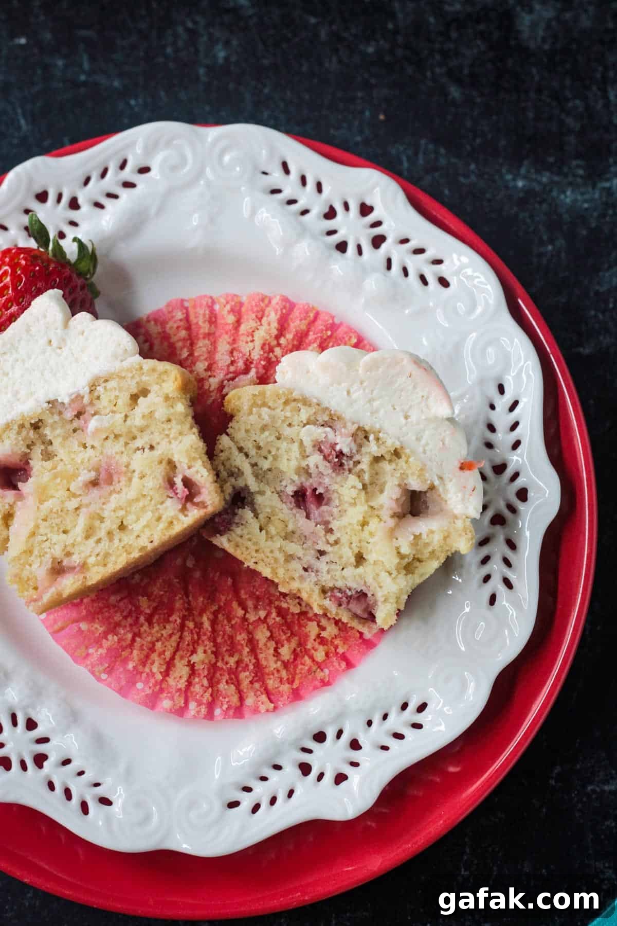 One baked cupcake cut in half on a plate.