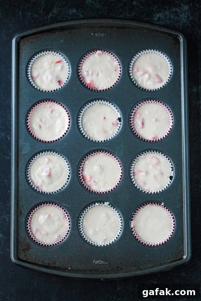 Raw batter poured into the cavities of a 12-cup cupcake pan.