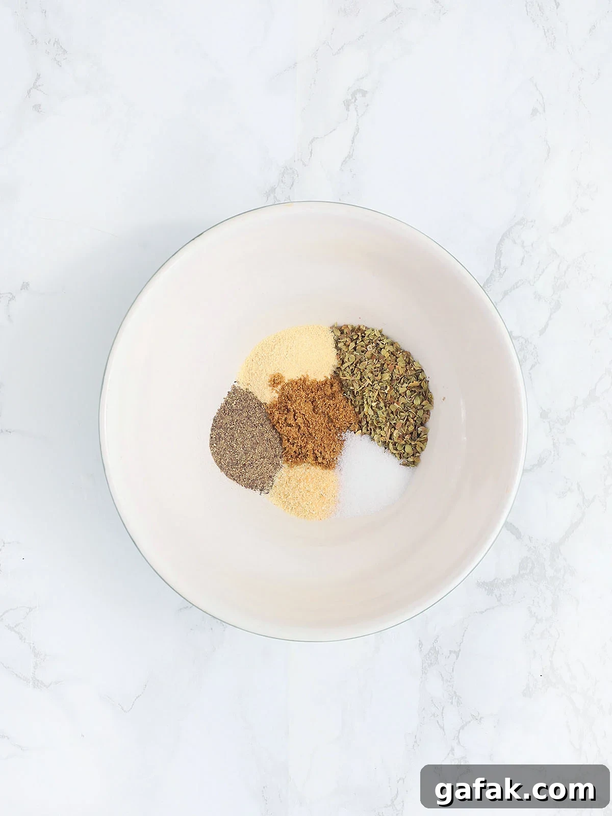 Seasoning ingredients unmixed in a small mixing bowl.